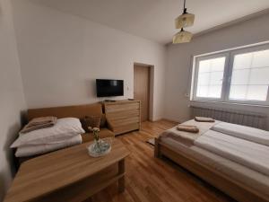 穆希纳Apartament pod Basztą的一间卧室设有两张床、一台电视和一张桌子