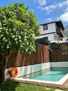 洛斯雷亚莱霍斯Casa La Aldaba的一座游泳池,位于树围栏前