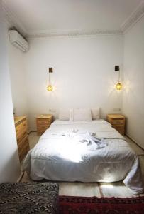 马拉喀什娜雅庭院旅馆的卧室配有一张白色大床和2个床头柜