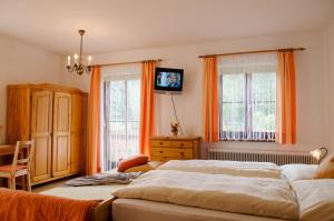 巴德加斯坦赛本霍夫农家乐的卧室内的两张床,配有橙色窗帘
