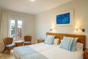 普拉亚布兰卡Apartamentos LIVVO Coloradamar的酒店客房设有两张床和窗户。