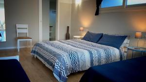 布多尼La Pecora Nera B&B的一间卧室配有一张带蓝色和白色棉被的床