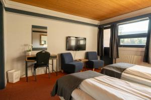 RendalenØiseth Hotell AS的酒店客房设有两张床、一张桌子和一台电视。