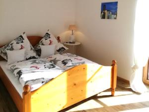 希格斯多夫Ferienwohnung zum Gimpei的一间卧室配有带枕头的木床
