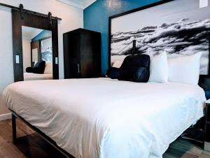 旧金山Signature Inn San Francisco Marina District的卧室配有白色床,墙上挂着一幅大画
