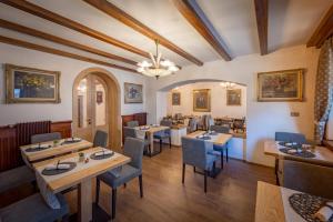 萨帕达Albergo Cavallino的一间在房间内配有桌椅的餐厅