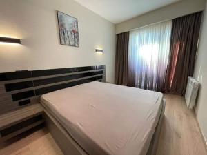 巴库里阿尼Crystal Residence Apartment 224的卧室配有白色的床和窗户。