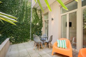 波尔图Alegria Colour Apartments的一个带桌椅和绿色墙壁的庭院