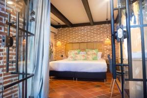 卡塔赫纳Los Patios Hostel的一间卧室设有一张床和砖墙