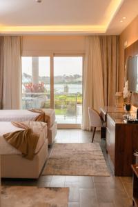 开罗Nile Club hotel的酒店客房设有两张床、一张书桌和一个窗户。