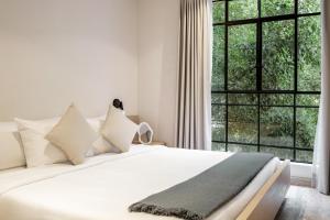 墨西哥城Nido Condesa by RentinBA的卧室配有白色的床和大窗户