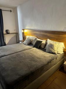 圣米格尔-德阿连德Good Hostel的卧室内的一张大床,配有木制床头板