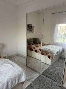 班珠尔Luxury 2 bedroom flat KerrSerign的带镜子的客房,配有一张床和镜子