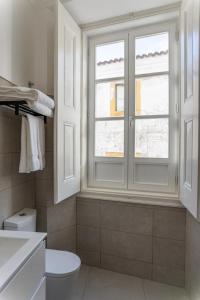 埃武拉Guest House - Palácio Diana的一间带白色卫生间的浴室和窗户。