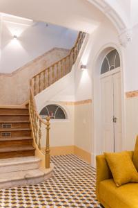 埃武拉Guest House - Palácio Diana的客厅设有楼梯和黄色沙发