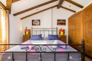 里斯卡Holiday Home Svjetlana的一间卧室配有带紫色枕头的金属床