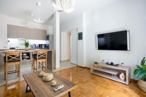 雅典Astrea 1- Bedroom Apartment in Athens的厨房以及带桌子和电视的客厅。