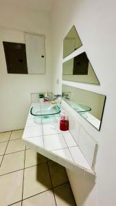 圣何塞SJO Oasis Hostel的白色的柜台,配有水槽和镜子