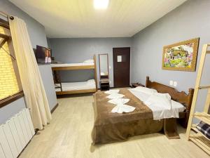 卡内拉Pousada Bella Serra的一间卧室配有一张床和一张双层床。