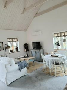 斯塔德Mysigt hus i liten by nära havet的客厅配有白色的沙发和桌子
