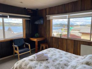 卡斯特鲁Hostal Plaza Chiloe的一间卧室配有一张床,享有水景