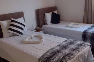阿拉亚尔-杜卡布Beira Mar Residencial的一间卧室配有两张带毛巾的床