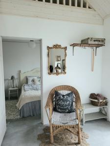 斯塔德Mysigt hus i liten by nära havet的一间带椅子和一张带镜子的床的房间