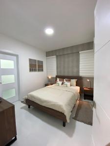圣多明各JRVII的卧室配有一张带白色墙壁的大床