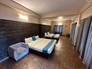 PadinjaratharaMisty Dam Wayanad Premium Resort With Banasura Dam View的酒店客房,配有两张床和椅子