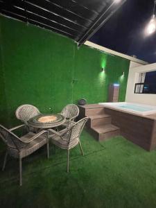 圣多明各Studio 27的一间设有绿色墙壁和桌椅的客房