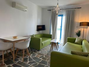 帕福斯Tasmaria Aparthotel的客厅配有绿色沙发和桌子