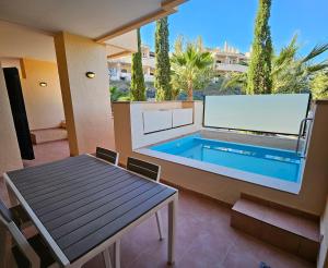 穆尔西亚Private Apartment & Pool - El Oasis Golf Resort - Fuente del Alamo的庭院设有游泳池、桌子和桌子