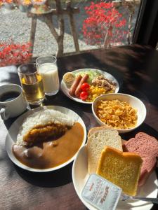 轻井泽轻井泽町罗索酒店的餐桌,盘子上放着食物,面包和牛奶
