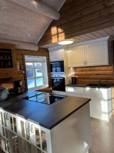 TjørhomHoliday cottage with sauna close to Kjerag的厨房配有白色橱柜和黑色台面