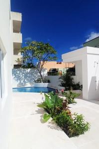 莫雷洛斯港Edifico con departamentos amplios cerca de la playa的一座白色的建筑,在院子里设有游泳池