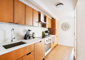 纽约Unique Studio Apartment At East Side的一个带木制橱柜和水槽的厨房