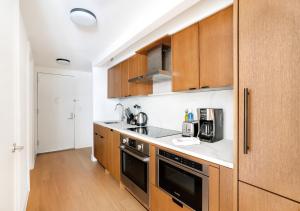 纽约Unique Studio Apartment At East Side的厨房配有木制橱柜和炉灶烤箱。