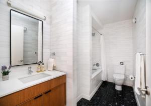纽约Unique Studio Apartment At East Side的白色的浴室设有水槽和卫生间。