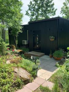 IlmanduSmall cozy 3-room house with terrace & large garden的花园里有门的黑色棚子