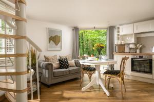 布兰德福德福鲁姆Honeycombe - Treehouse in the Heart of Dorset的厨房以及带桌子和沙发的客厅。