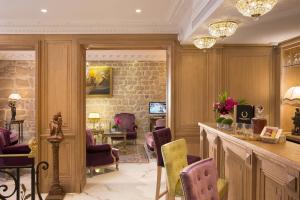 巴黎圣日耳曼学院酒店的沙龙设有酒吧,配有紫色和黄色椅子