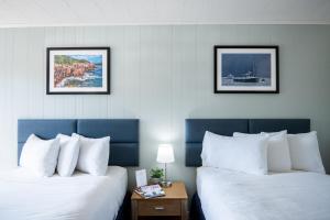 巴港泊宿汽车旅馆的两张位于酒店客房的床,墙上有两张照片