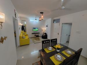 海得拉巴NK Homes - Serviced Apartments的一间带桌子和黄色椅子的用餐室