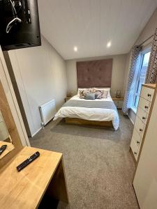 纽基Luxury 3 bedroom Maple View Lodge, Newquay, Cornwall的一间卧室配有一张床和一台电视