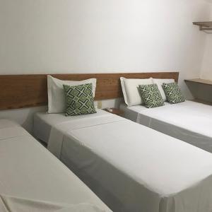 伊塔卡雷Bahia Bonita Flat的白色墙壁客房的两张床
