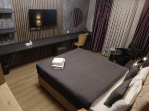 伊斯坦布尔Nomad Hub Istanbul Residence的配有一张床和一台平面电视的酒店客房