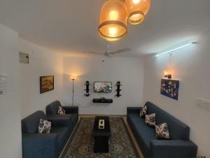 海得拉巴NK Homes - Serviced Apartments的客厅配有2张蓝色的沙发和1张桌子