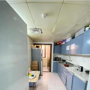 阿布扎比Single Room Near "World Trade Centre&Beach" Abudhabi的厨房配有蓝色橱柜和冰箱。