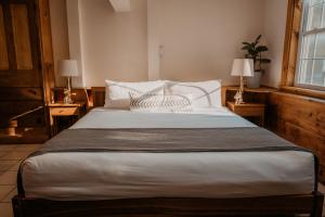 East BurkeThe Village Inn的一间卧室配有一张带两盏灯的大型白色床。