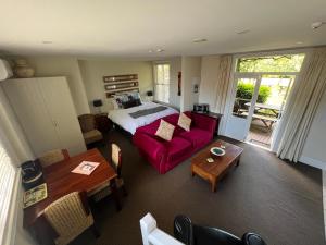 马丁伯勒比诺别墅酒店的客厅配有床和红色沙发
